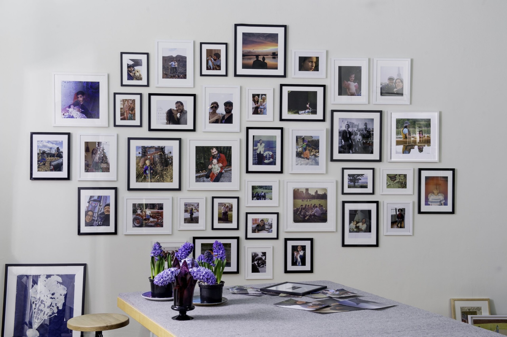 Curated gallery wall of framed photographs above a studio table
