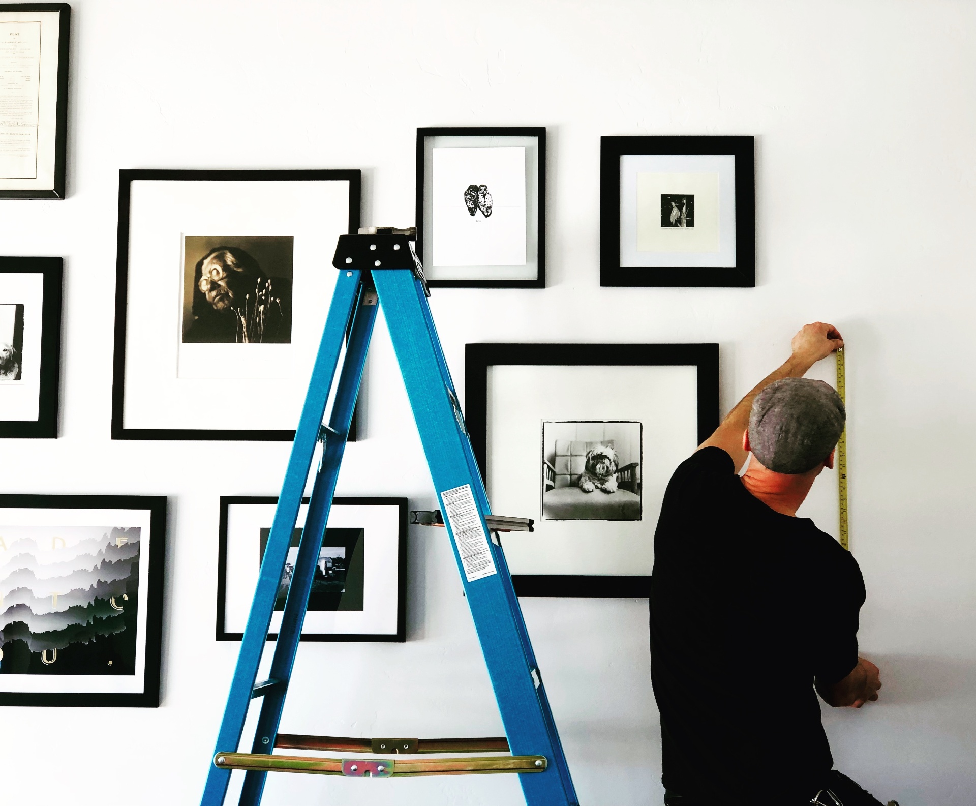 Art installer hanging a framed picture in a Ketchum, Idaho home