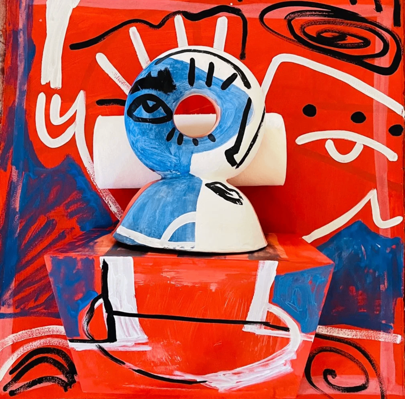 Mixed-media work by Sally King Benedict featuring a sculptural face on a vivid red painted background, available at Hemmings Gallery